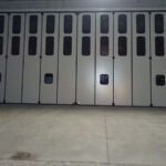 Portone a libro con guida a pavimento e porte pedonali ai lati